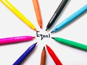 Photo by Aiman Inam - copyfind.net Colorful markers arranged in a circle on white paper around the word 'Equal'.